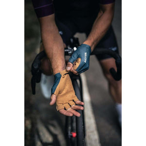 Cyclist wearing Hestra fingerless cycling gloves with tan palms and blue backs