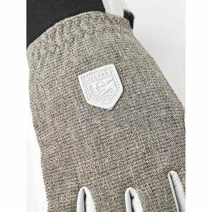 Close up of Hestra glove with textured grey fabric and brand logo patch