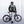 Person wearing a green Thule backpack and black helmet standing with a black bicycle
