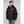 Man wearing a black Helly Hansen hooded rain jacket over a blue zip up layer