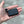 Small black rectangular battery pack with an L-shaped power connector held in a palm