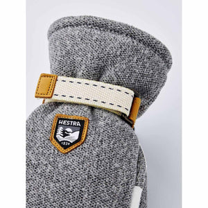 Hestra grey wool mitten with adjustable canvas strap and brand logo patch