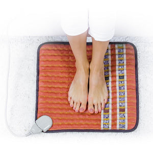 Person standing barefoot on a HealthyLine gemstone heating mat