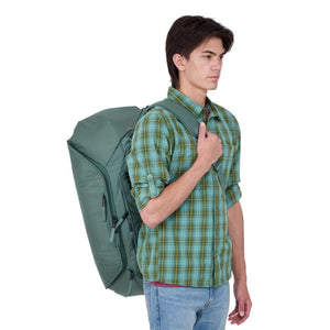 Person wearing a green Thule duffel backpack
