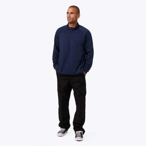 Man wearing a navy blue Mobile Warming quarter zip pullover and black cargo pants