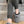 Person wearing grey cable knit ActionHeat slippers while sitting on carpeted stairs