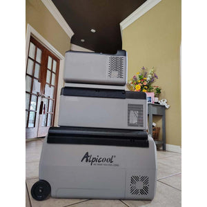 Three Alpicool portable refrigerators stacked vertically on a tiled floor