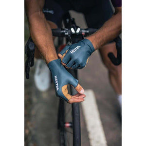 Cyclist wearing blue and tan Hestra fingerless cycling gloves on handlebars