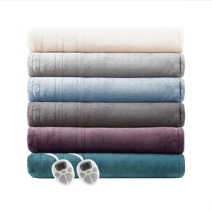 Stack of six folded Serta heated blankets in various colors with two digital controllers