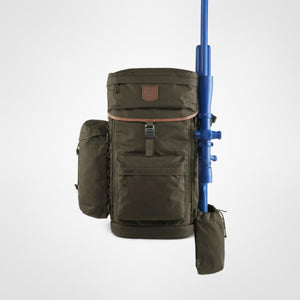 Fjallraven Singi hunting backpack in dark olive with a blue rifle attached to the side