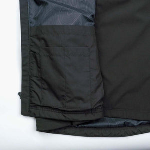 Interior view of a black Mobile Warming jacket showing the pocket lining and fabric detail