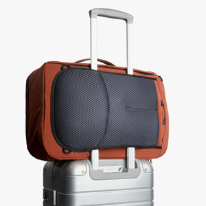 Bellroy travel bag attached to a silver rolling suitcase handle
