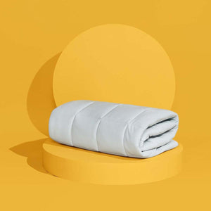 Folded Outlast comforter on a yellow circular pedestal