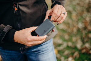 Person connecting a power bank to an ActionHeat heated jacket
