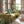 Vornado pedestal fan in mint green in a living room with brick walls