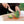Person cutting broccoli on a wooden board with a Snow Peak knife