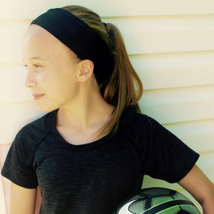 Girl wearing Oro Sports black headband and athletic shirt holding a soccer ball