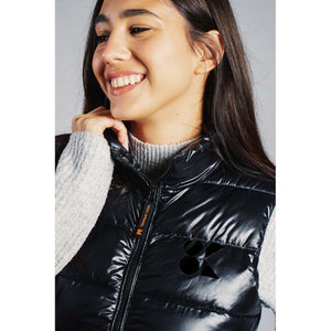 Woman wearing a black 8K FlexWarm quilted vest over a grey sweater