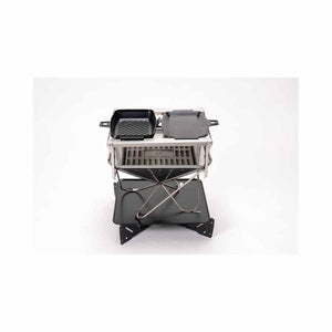 Snow Peak camping stove with two cast iron grill plates on a metal stand