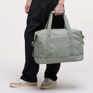 Person holding a sage green Got Bag duffel bag