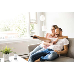 Couple sitting on a couch using a HealthyLine remote control