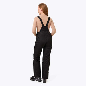 Back view of a person wearing black ski bib pants and Nordica ski boots