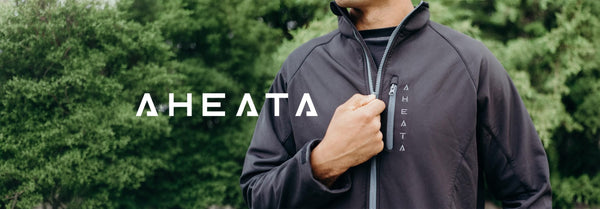 A man zips a dark gray jacket with 