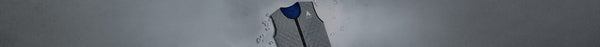 A grey quilted cooling vest with a blue interior and white mountain logo, surrounded by scattered ice cubes, rests on a light grey surface.