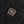 Black square power button with red R logo on black fabric