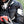 Motorcyclist wearing black Acerbis jacket and helmet holding a red smartphone