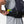 Person placing energy gel into the side pocket of a black Nathan hydration vest