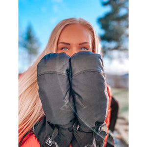Person holding Heat Experience black heated mittens in front of face