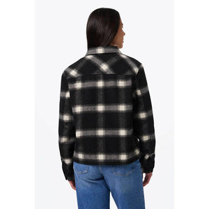 Back view of a person wearing a Mobile Warming black and white plaid flannel jacket with blue jeans