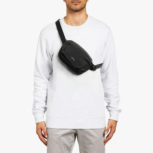 Person wearing a black Bellroy sling bag across the chest