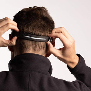 Person adjusting the reflective strap of a BioLite headlamp