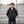 Boy wearing a black ActionHeat hooded heated jacket standing in front of stadium bleachers