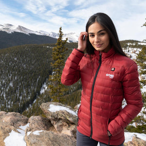 Woman wearing a red Gobi Heat jacket on a snowy mountain trail