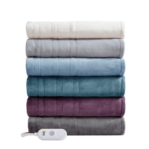 Stack of six folded Serta heated blankets in various colors with a white remote control