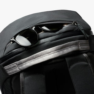 Black Bellroy backpack with sunglasses stored in the top zippered pocket