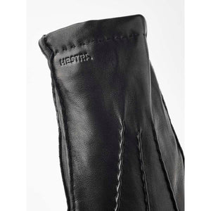 Black Hestra leather glove cuff with embossed logo