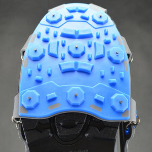 Winter Walking ice cleat with blue rubber traction pad and metal studs on a black shoe sole