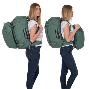 Woman wearing a green Thule travel backpack with a detachable daypack