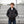 Boy wearing a black ActionHeat hooded puffer jacket standing in front of stadium bleachers