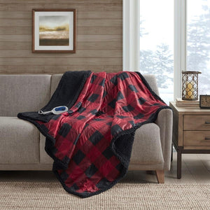 Red and black buffalo plaid electric throw blanket with black sherpa lining on a sofa