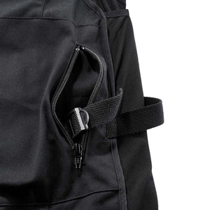 Close up of black work trousers featuring a zippered pocket and an adjustable side strap