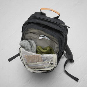 Open FjallRaven backpack with internal pockets containing a charging cable and folded clothing