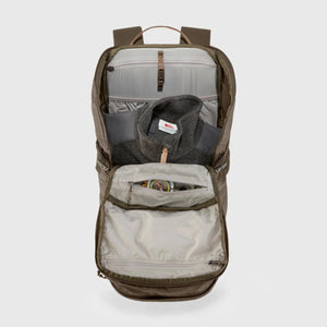 Open Fjallraven backpack showing internal compartments with a fleece jacket and compass