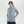 Woman wearing a light blue Outdoor Research hooded rain jacket with zippered pockets