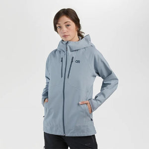 Woman wearing a light blue Outdoor Research hooded rain jacket with zippered pockets