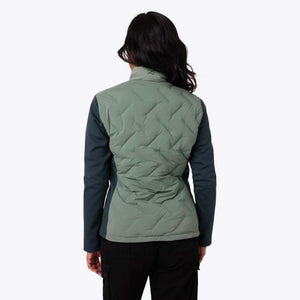 Back view of a woman wearing a sage green Mobile Warming quilted jacket with dark sleeves